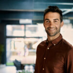 Portrait,Of,A,Smiling,Young,Businessman,Standing,Alone,In,A